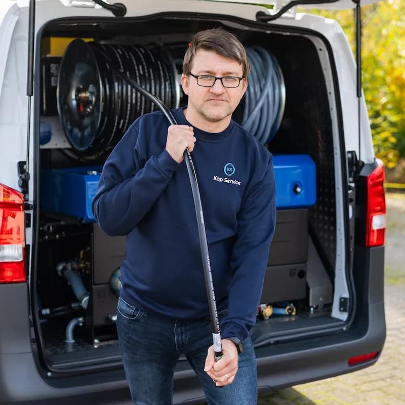 Techniker von Kap Service mit Hochdruckschlauch am Einsatzfahrzeug
