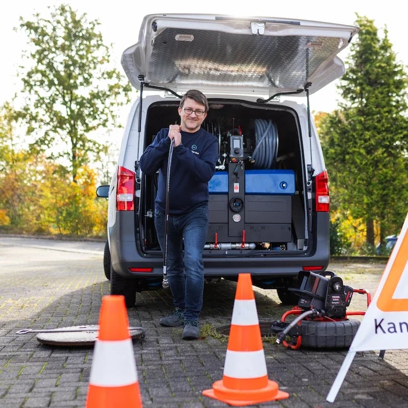 Kap Service am geöffneten Kanalschacht, abgesichert mit Leitkegeln