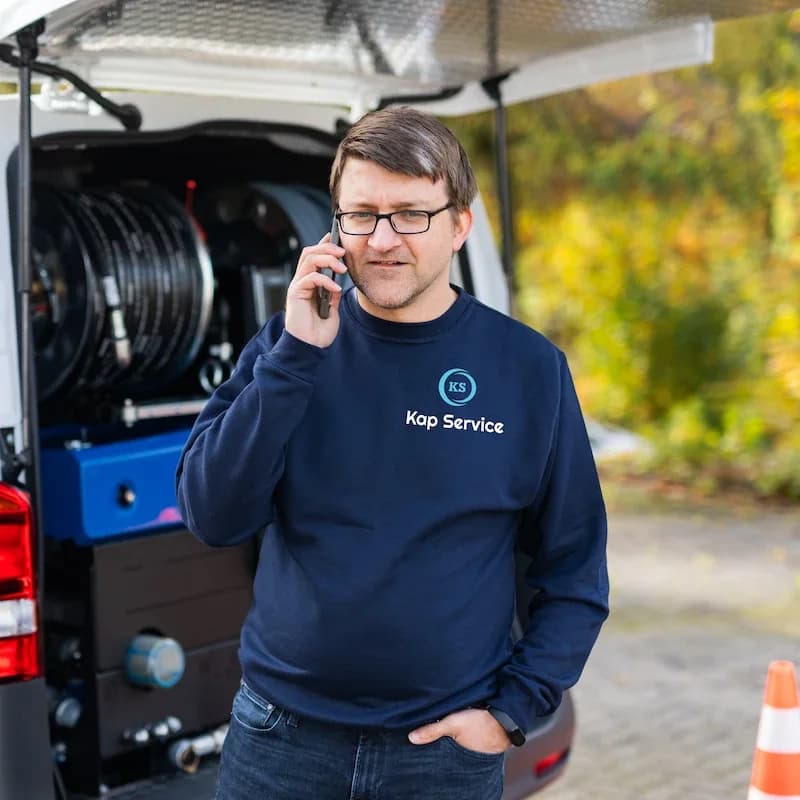 Techniker nimmt am Einsatzfahrzeug einen Notruf an